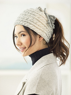 woman wearing a cabled messy bun beanie