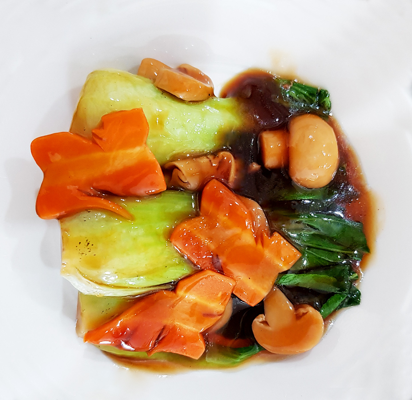 Pakcoy saus tiram disajikan dengan sayuran hijau, wortel dan jamur menghasilkan rasa lezat dan aroma khas