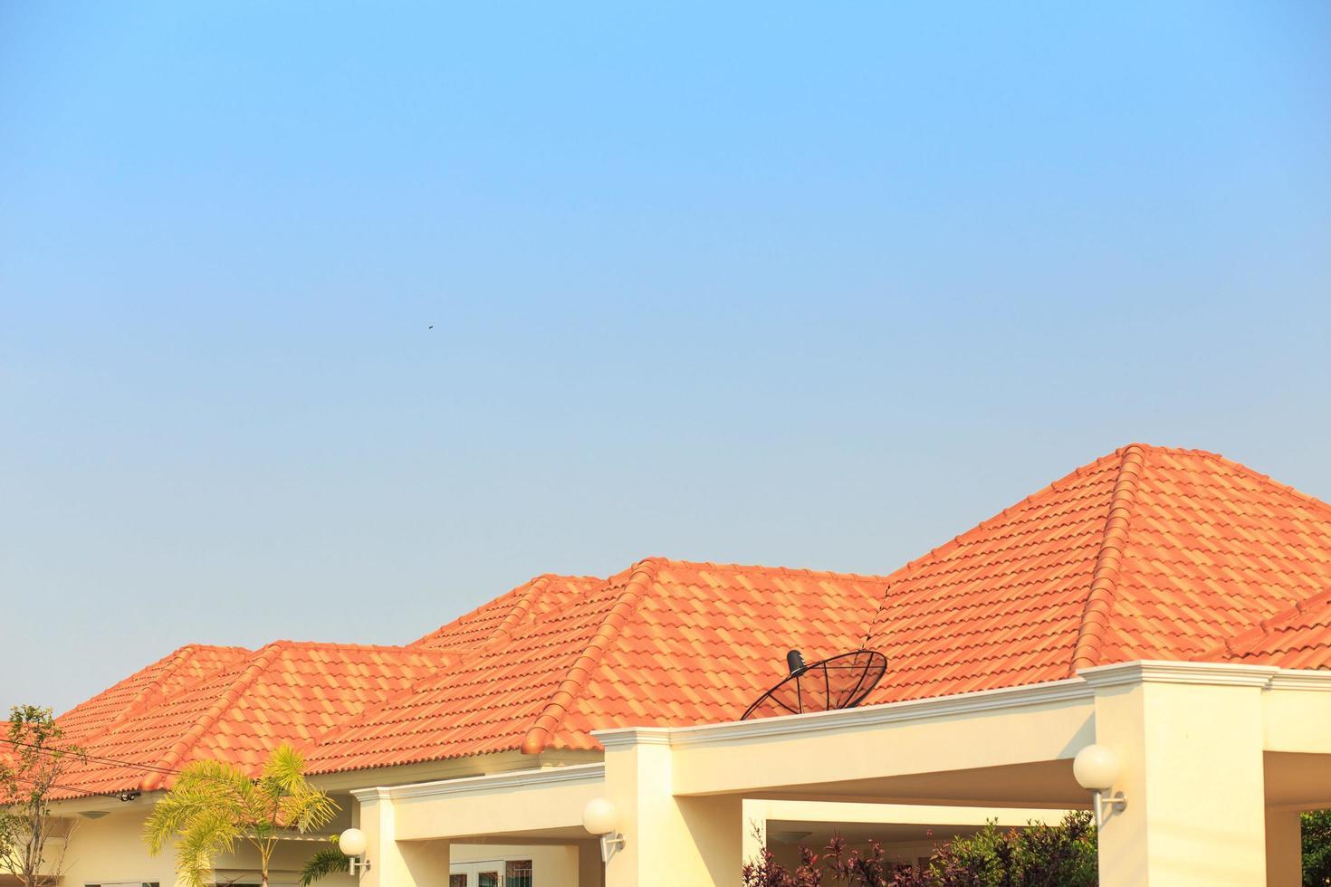WeServe house with orange tile shingles on the roof against a blue sky