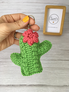 hand holding a mini crochet cactus keychain