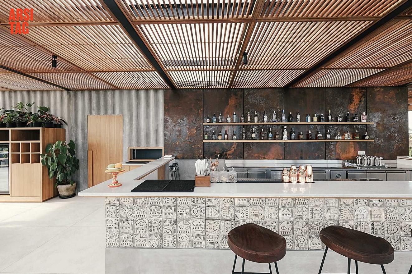 Dinding backsplash dapur terbuka berupa deretan lempengan besi warna karat, Karya Kkum Architect via Arsitag