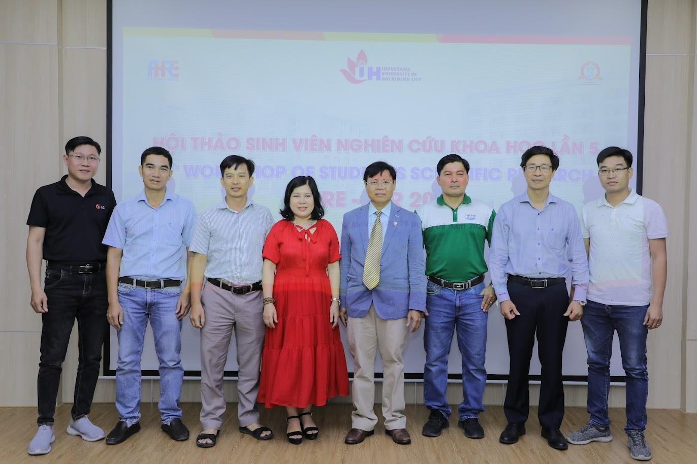 A group of people standing in front of a projector screenDescription automatically generated