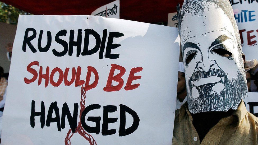 An Indian Muslim wears a mask of Indian writer Salman Rushdie as he displays a placard condemning Rushdie during a protest in Bombay, 12 January 2004. During the protest against Rushdie`s presence in the city, organised by several Muslim organisations, a reward of Rs.100,000 (2,199 USD) to anyone who blackens the face of Rushdie,who in his book The Satanic Verses allegedly made remarks against Islam`s holy prophet Mohammed.