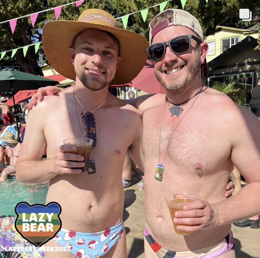 two gay males enjoying cocktails near the pool on lazy bear weekend 2023