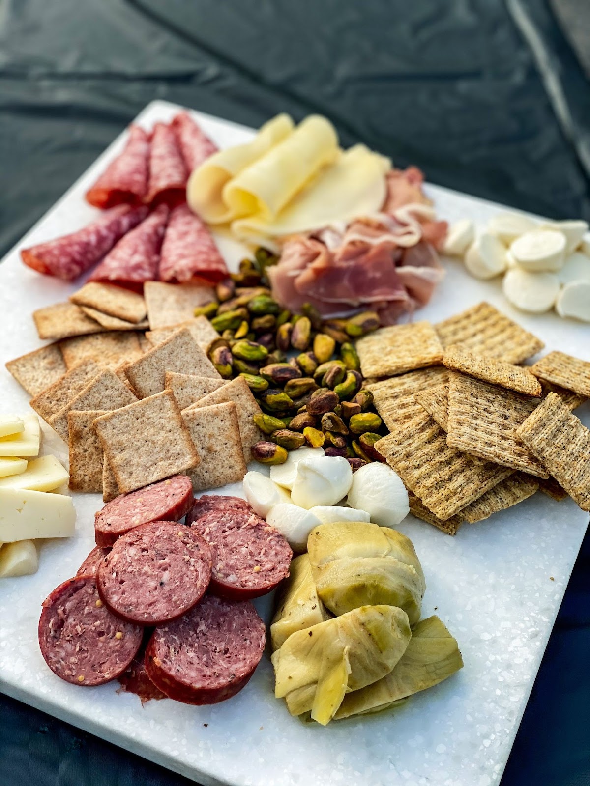 charcuterie board with cheese and salami and crackers