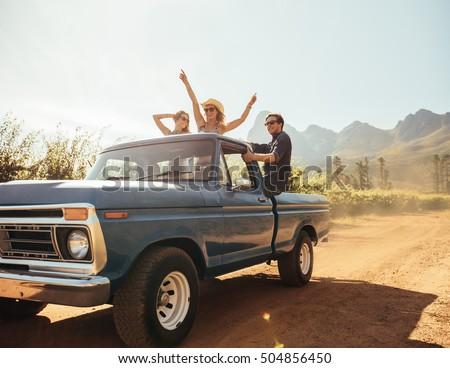 Group of people at the back of a pick up truck having fun