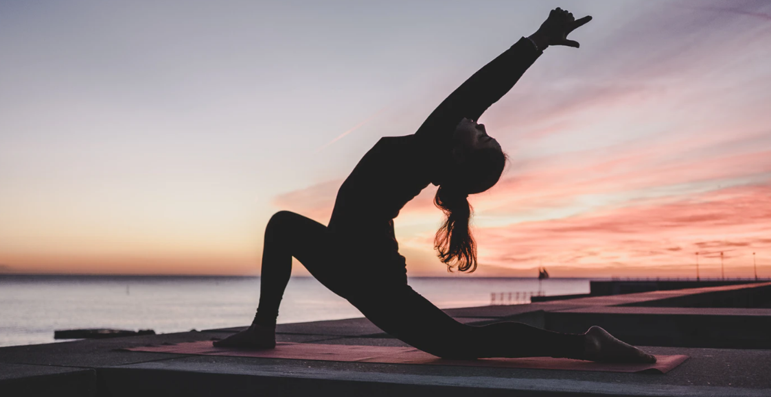 a woman in the sun set doing yoga exercises to relieve stress