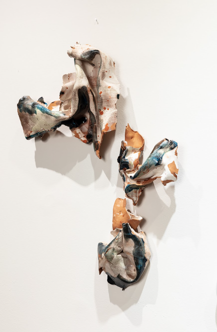 Image: Three pieces from Nanxi Jin’s Escape Plan series hang on the wall at Xiao Space Gallery. They are ceramics, twisting around themselves. Courtesy of the artist. 