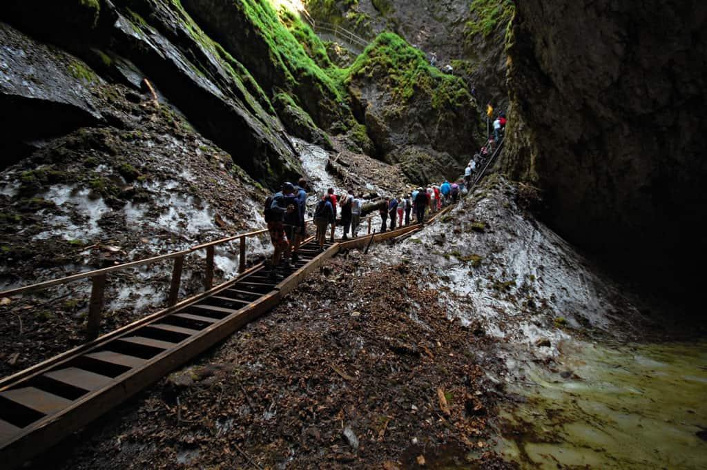 Line of people trekking through Scarisoara glacier cave, a great day trip from Cluj Napoca.