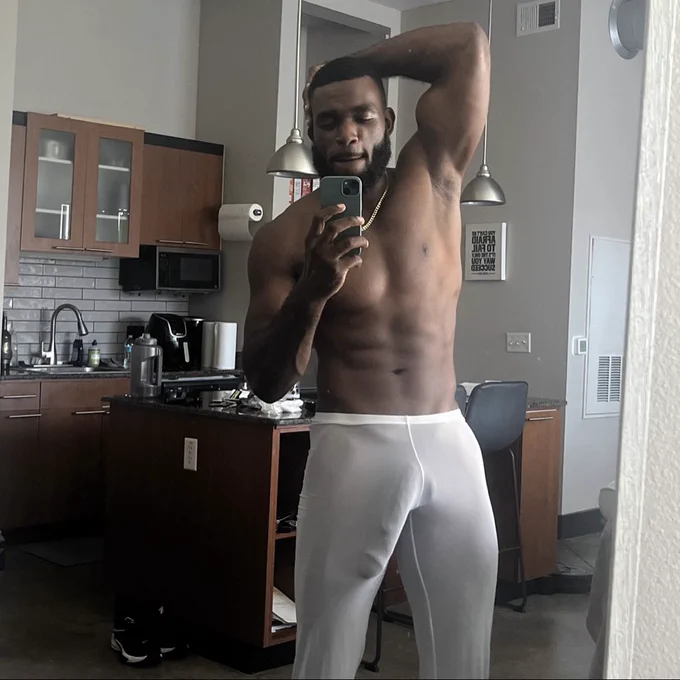 Marshall Price taking an iphone mirror selfie while posing with his arm out and his thick erect cock is peeking through transparent white pajama bottoms