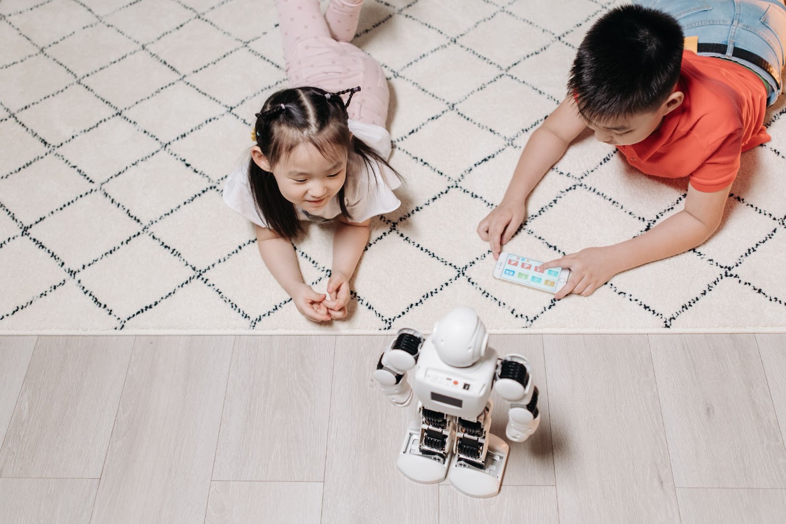 Kids on some child-friendly flooring playing with a robot