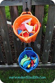 from www.ourwonderfilledlife.com - drill holes in buckets, hang on hook at height kids can reach near sandbox, instant sand toy organization!