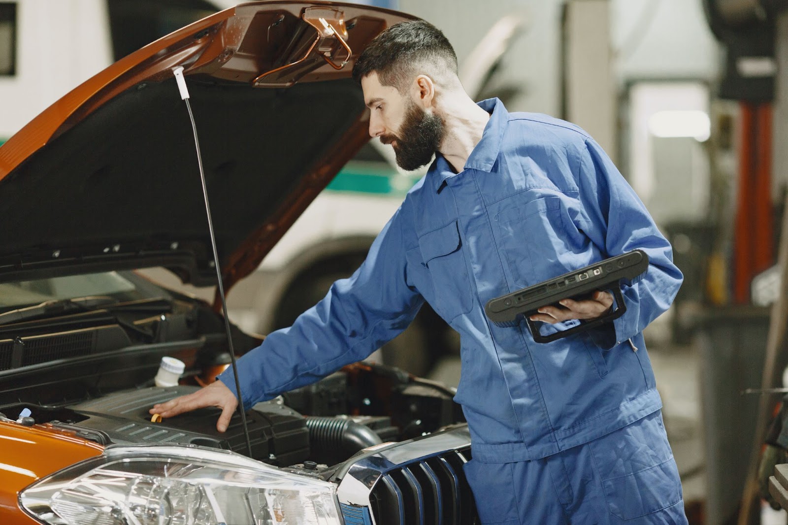 A mechanic checking the engine of a car.
