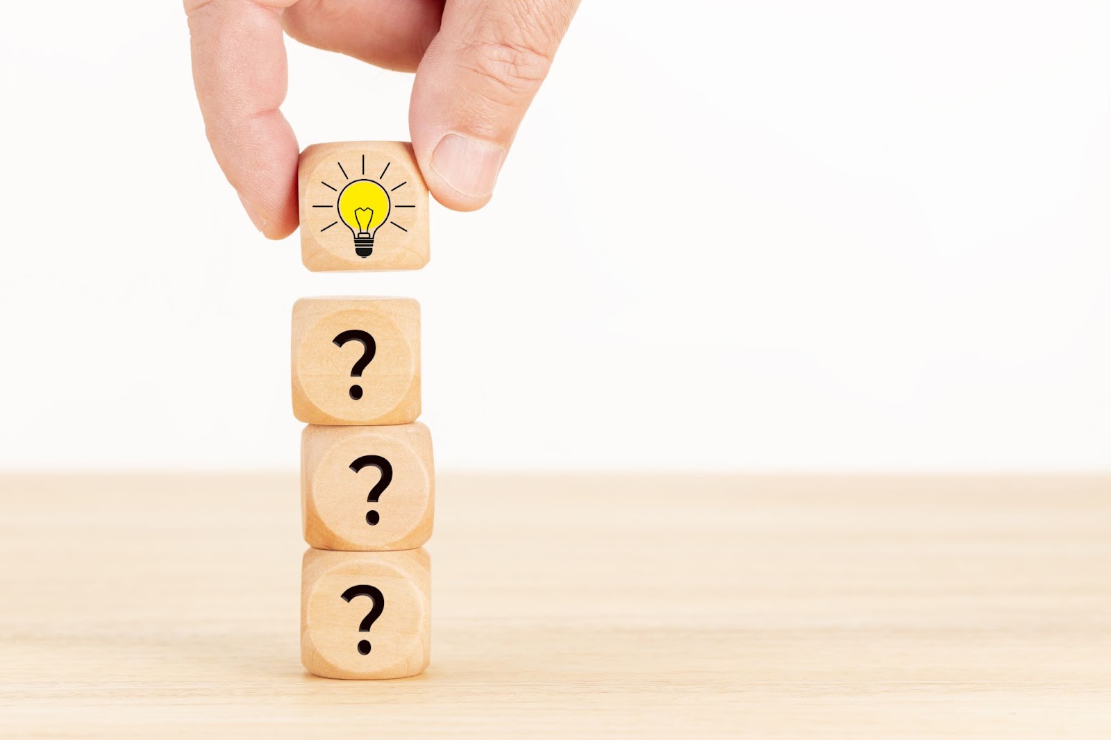 hand-picked wooden cube block with question mark symbol and light bulb icon