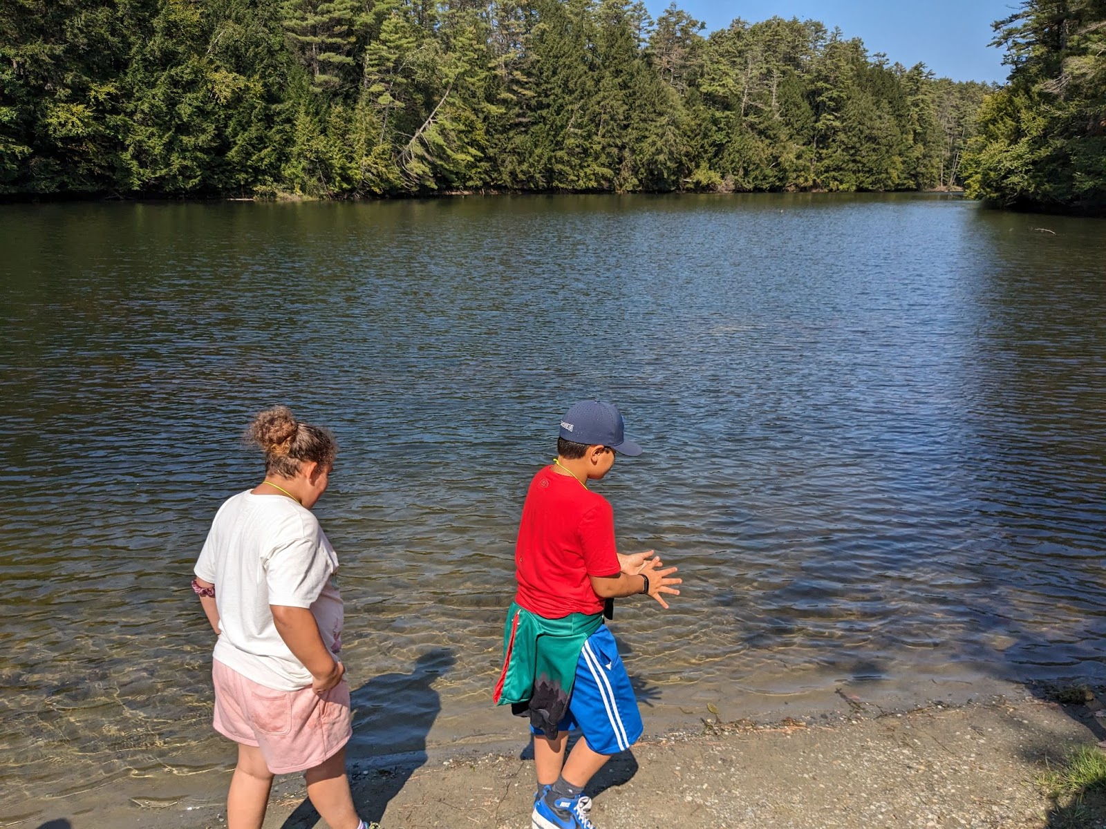 Two kids walking along the waters edge at Storrs Pond