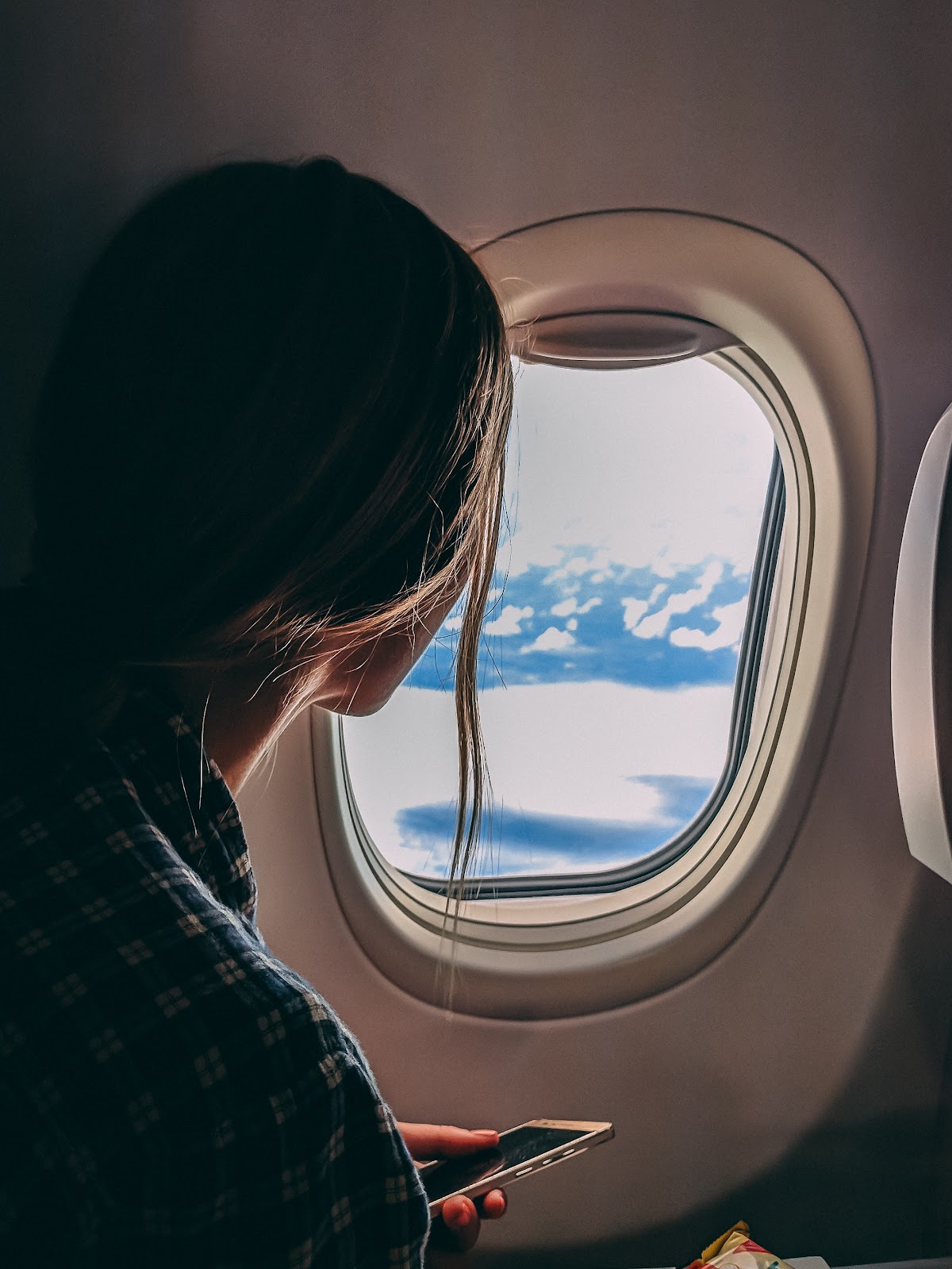 Woman looking at the sky from inside the plane