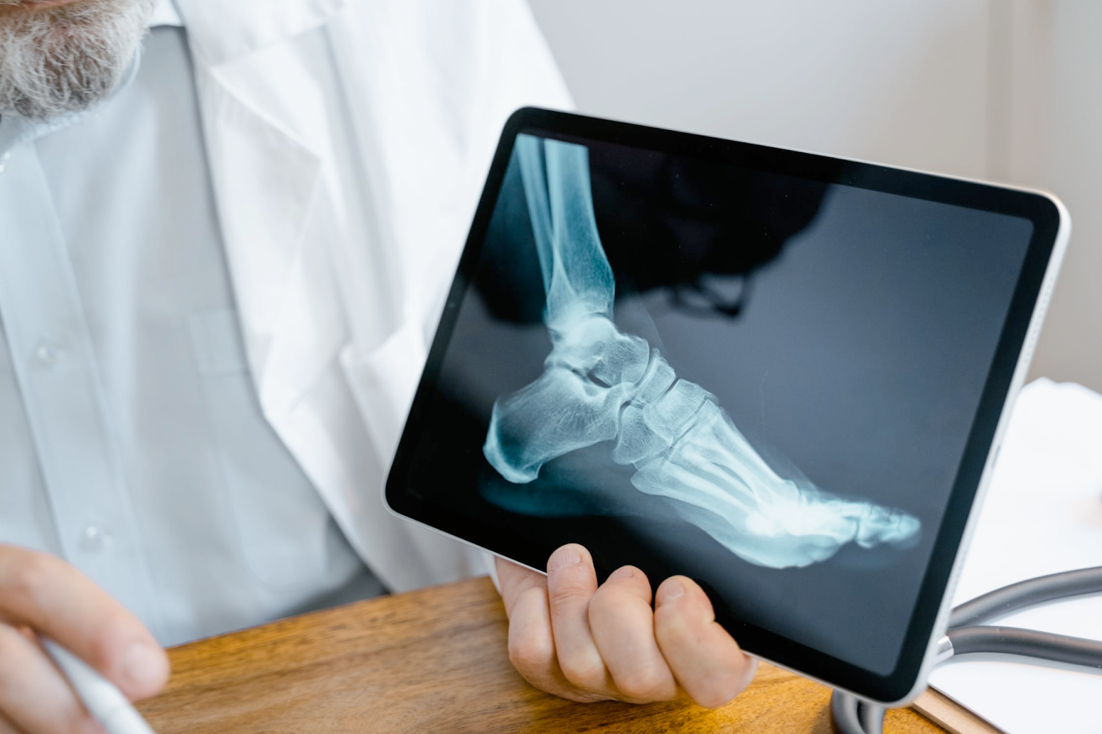 A doctor showing the anatomy of the bones in a foot through an iPad