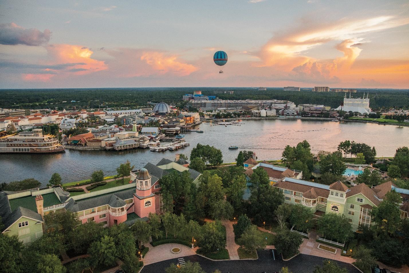 Beautiful sunset with hot air balloon in distance and view of river and colorful buildings. 