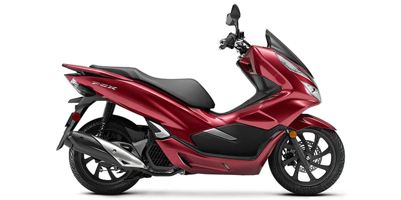 Maroon Honda PCX150 ABS scooter parked on city street - advanced safety features and sleek design for a comfortable and secure ride in urban areas