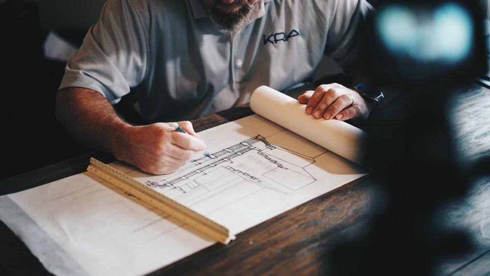 An architect working on a draft with a pencil and ruler.