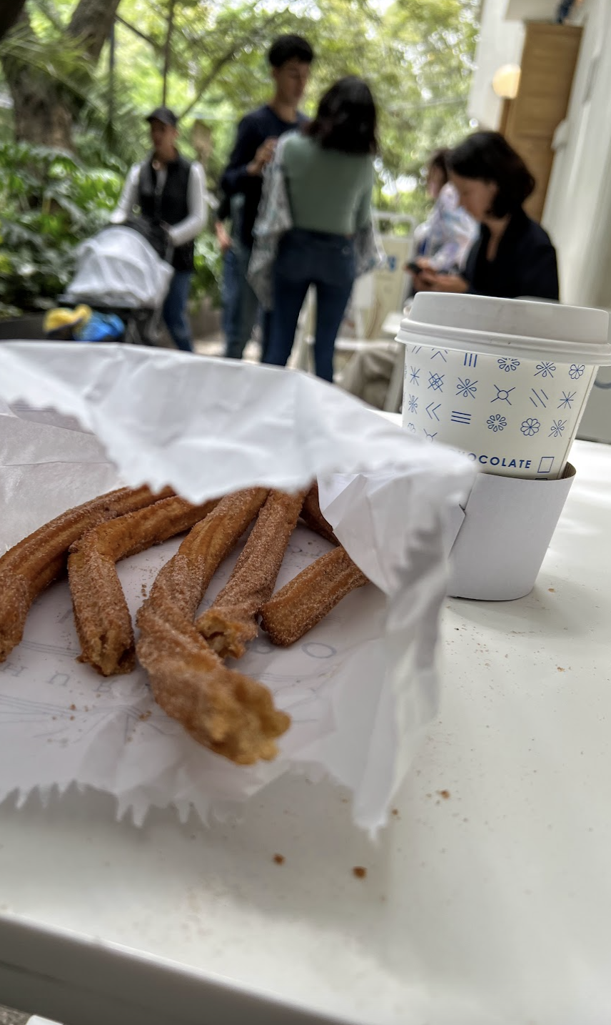 Photo of churros and hot chocolate on a table outside of Churros El Moro at Parque Mexico, Condesa.