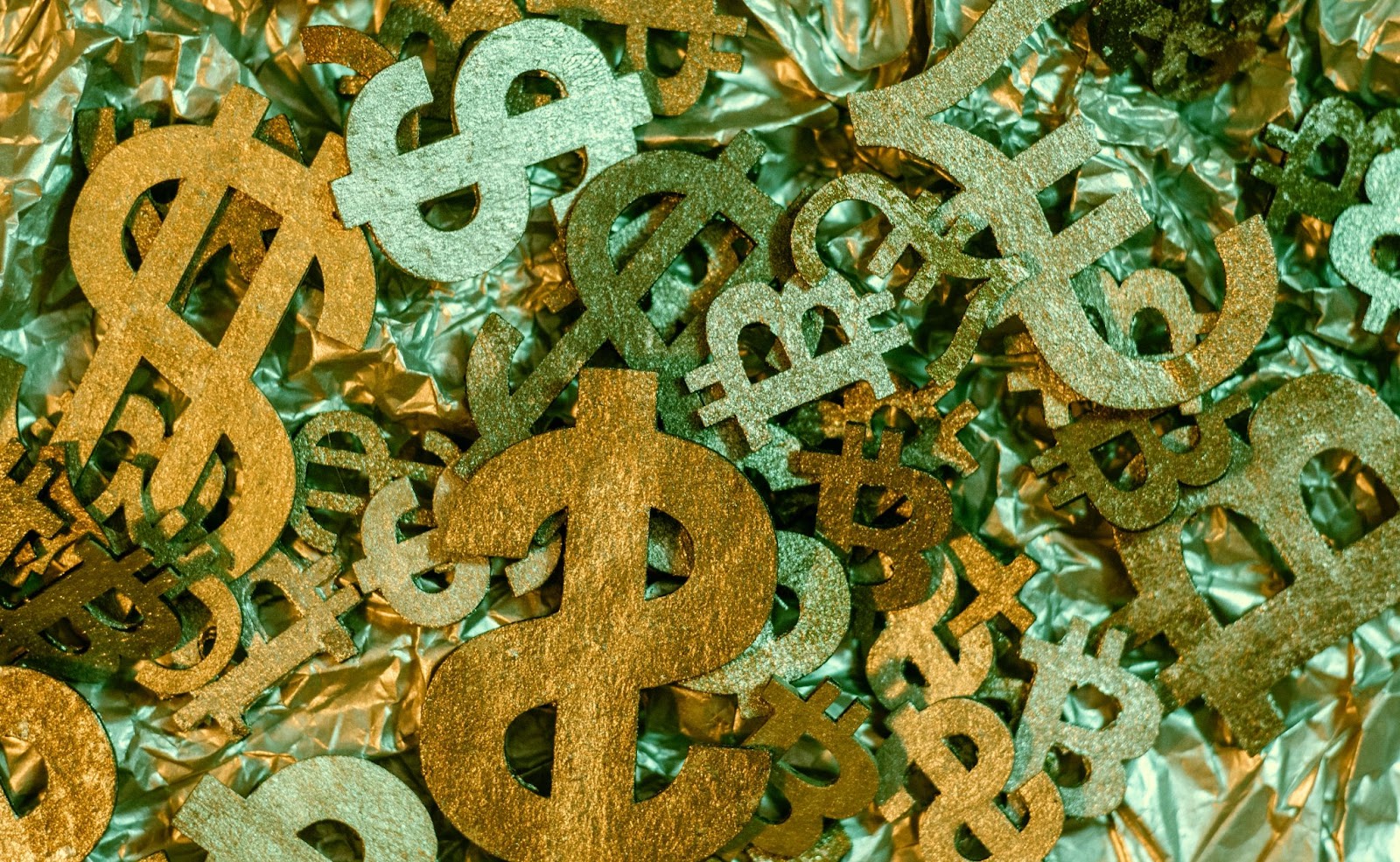 A pile of metal dollar signs and bitcoin  symbols