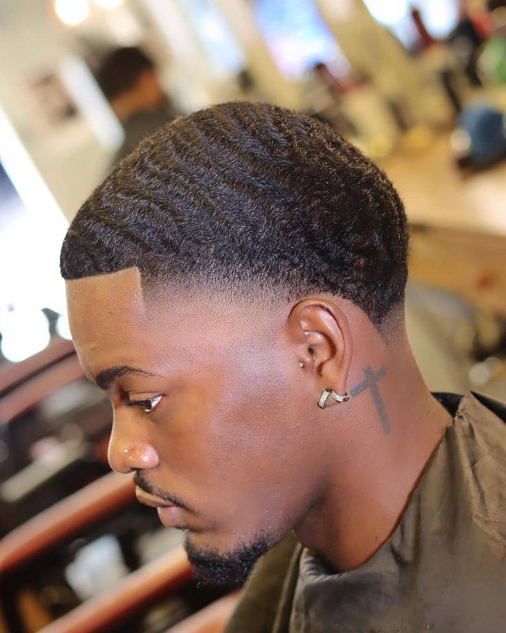 man with cross tattoo and waves rocking fade with short hair