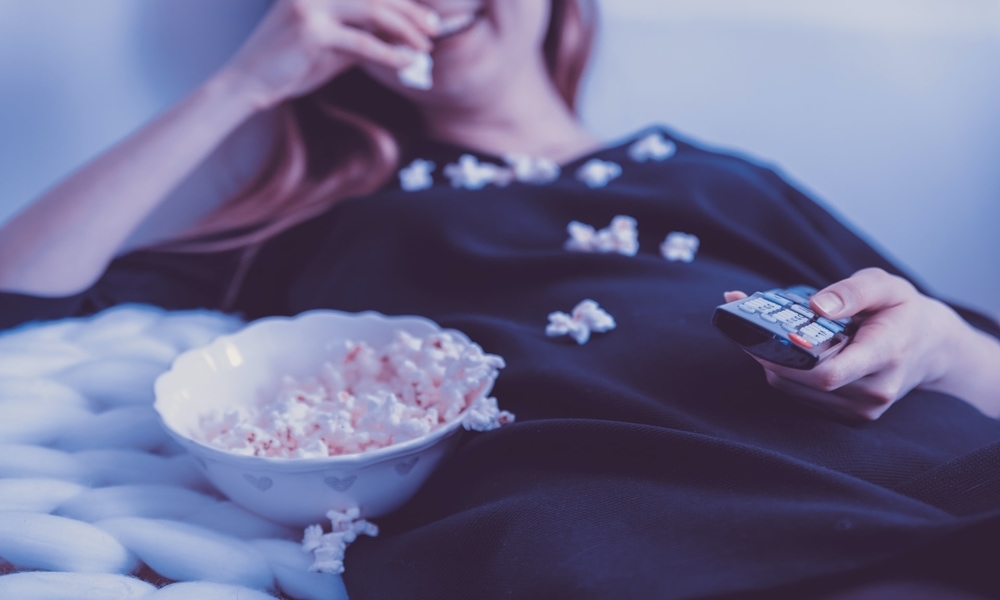 girl watching Spanish romance movie with popcorn