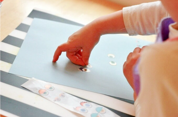 A child drawing using eye stickers
