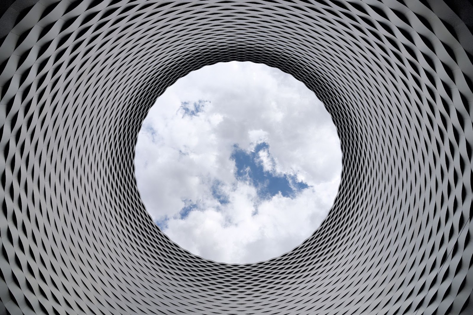 An image of a piece of sky, we are looking up at it through a spiralled tube.
