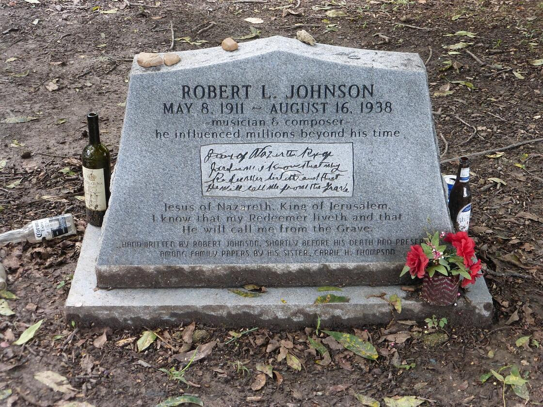 Robert Johnson’s (1911-1938) tombstone has some empty bottles around it and a flower. 
