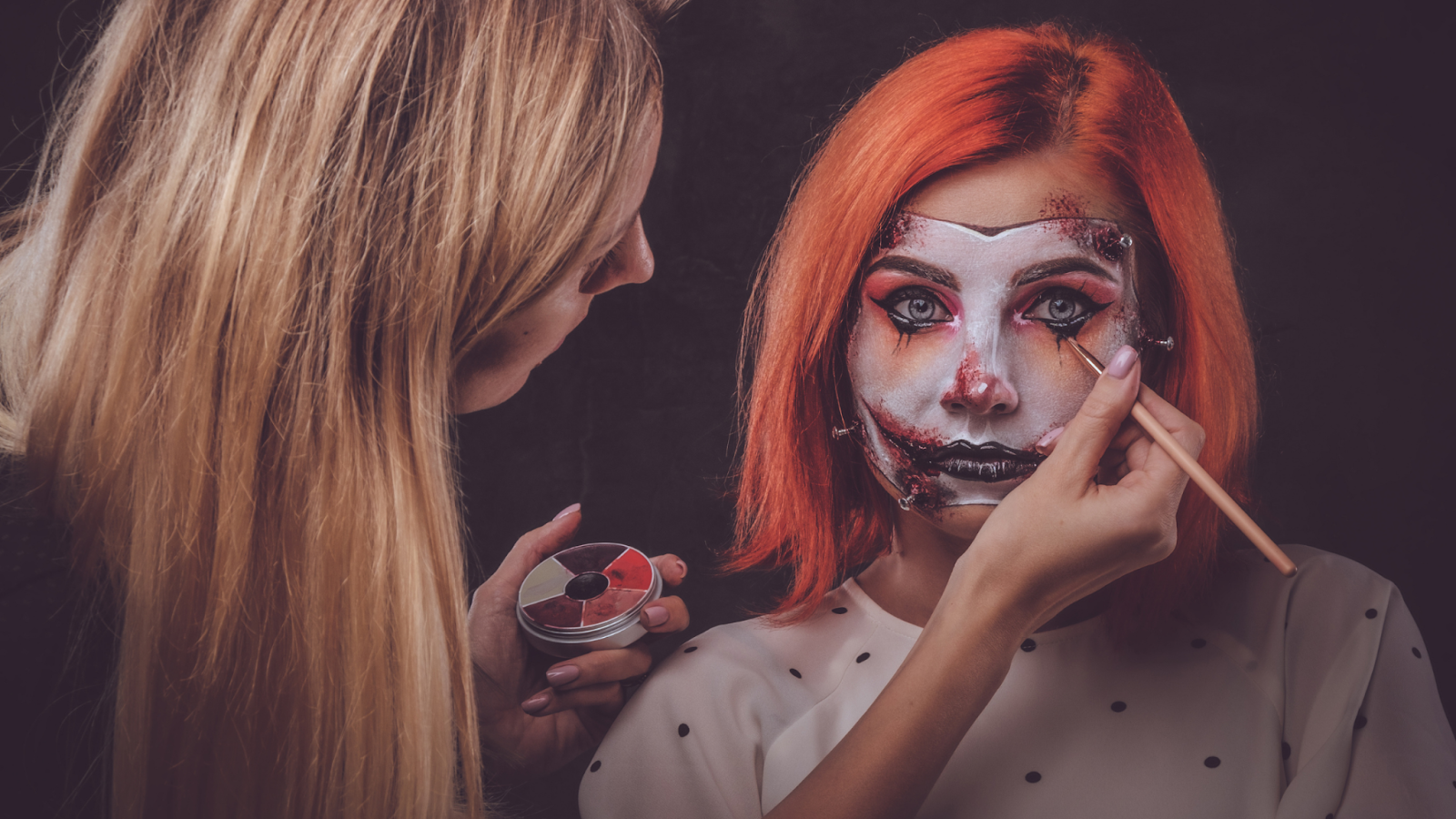maquiadora fazendo maquiagem de vampira em outra pessoa