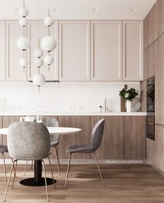 Elegant kitchen design with warm wood cabinets, modern pendant lighting, and a cozy dining area featuring velvet chairs and a sleek round table.