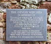 Plaque on a brick wall honoring victims of the Bideford, Devon Witch Trials. Victims names and year of death are inscribed.