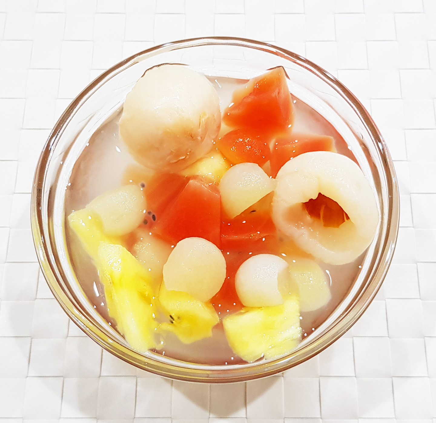 Es buah lebaran yang terdiri dari potongan buah leci, nanas, pepaya, air, gula dan lainnya