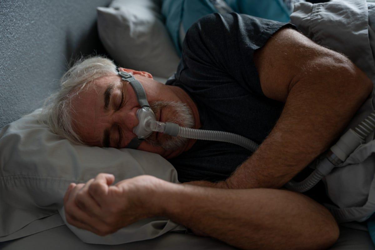 Mężczyzna śpiący na boku z aparatem CPAP