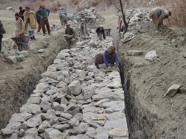 Labourers construct flood-control gabion walls - structures constructed by filling large galvanized steel baskets with rock – in northern Pakistan’s remote Bindo Gol valley. Credit: Saleem Shaikh/IPS