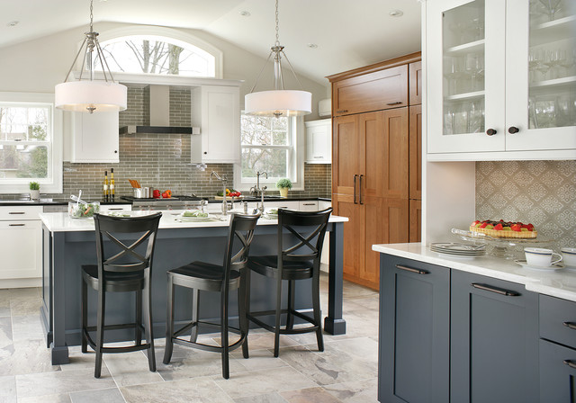 contemporary white and grey kitchen with a wall of maple cabinets. black barstool seating sits next to a charcoal and white center island. a glossy grey subway tile backsplash spans the back wall