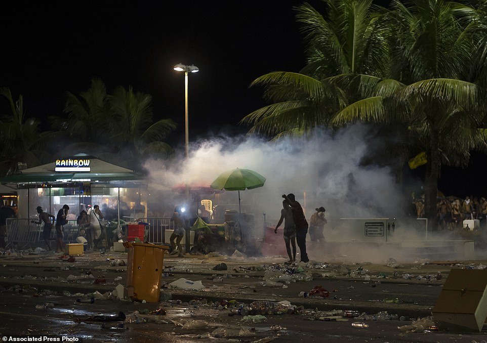 Revelers at Copacabana beach in Rio de Janeiro, Brazil, run for cover after unruly partygoers attacked the police, who then answered by  firing tear gas into the crowd