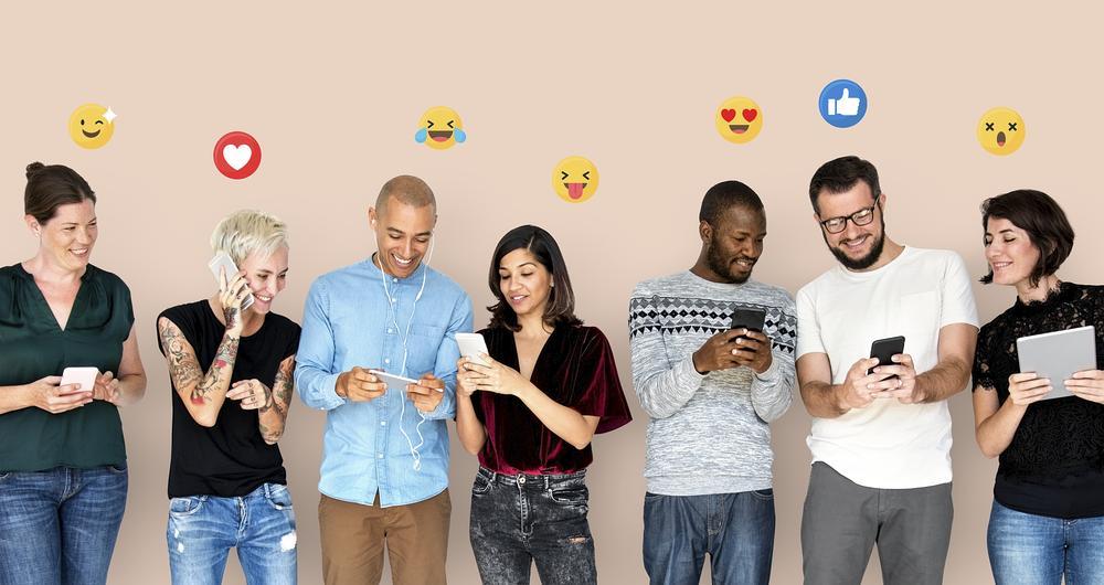 Pessoas diversas felizes usando dispositivos digitais