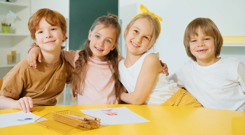 A group of children sitting at a table

