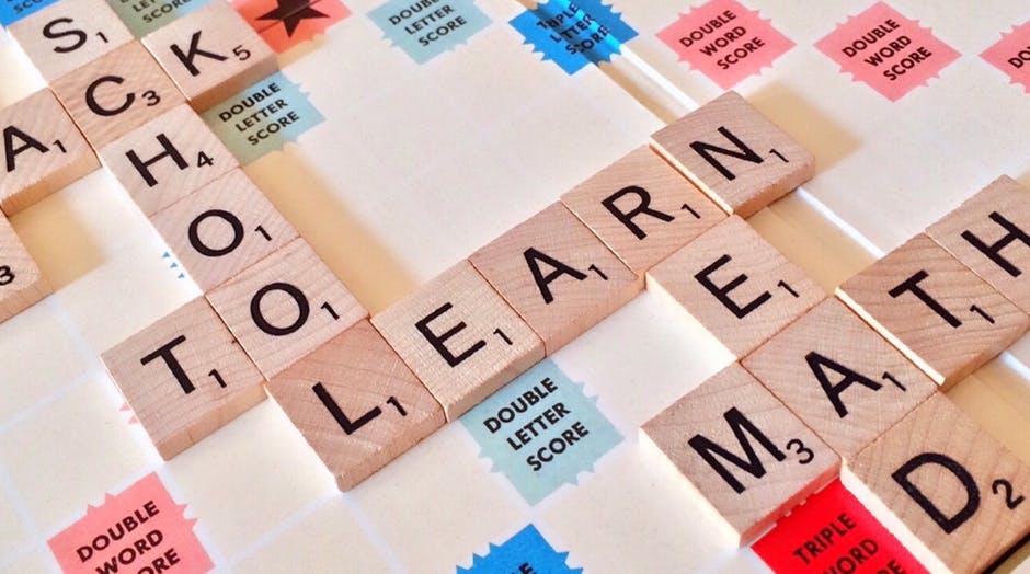 Scrabble tiles that spell out the words “School”, “Learn”, “Read”, and “Math”. 