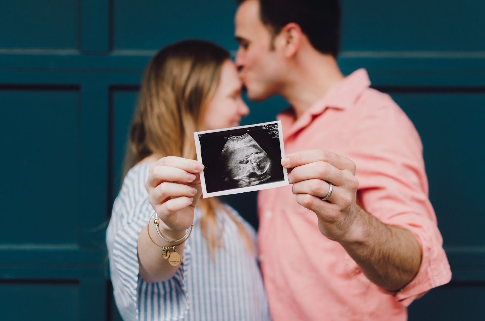 happy couple holds ultrasound baby photo