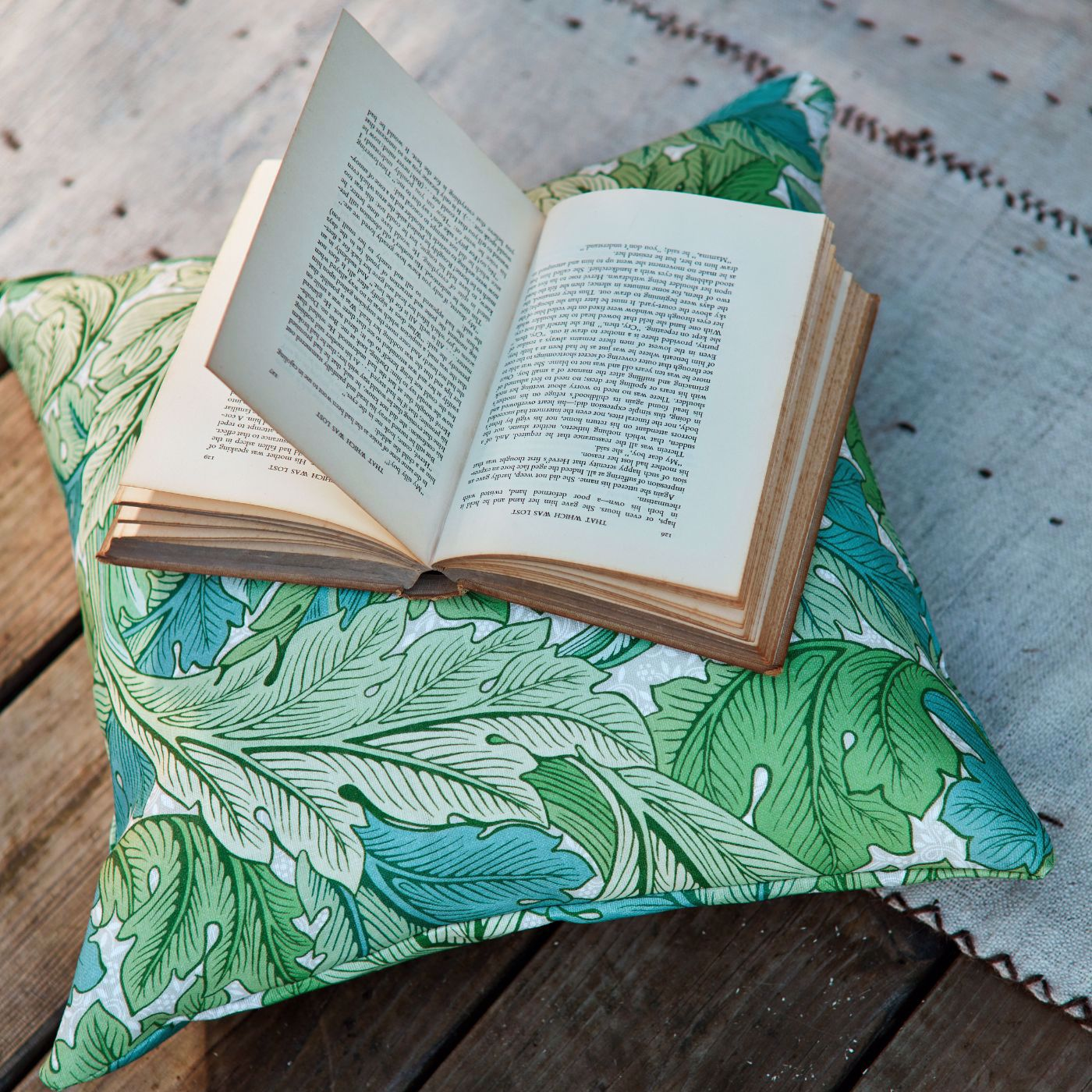An open book sitting on top of a green pillow