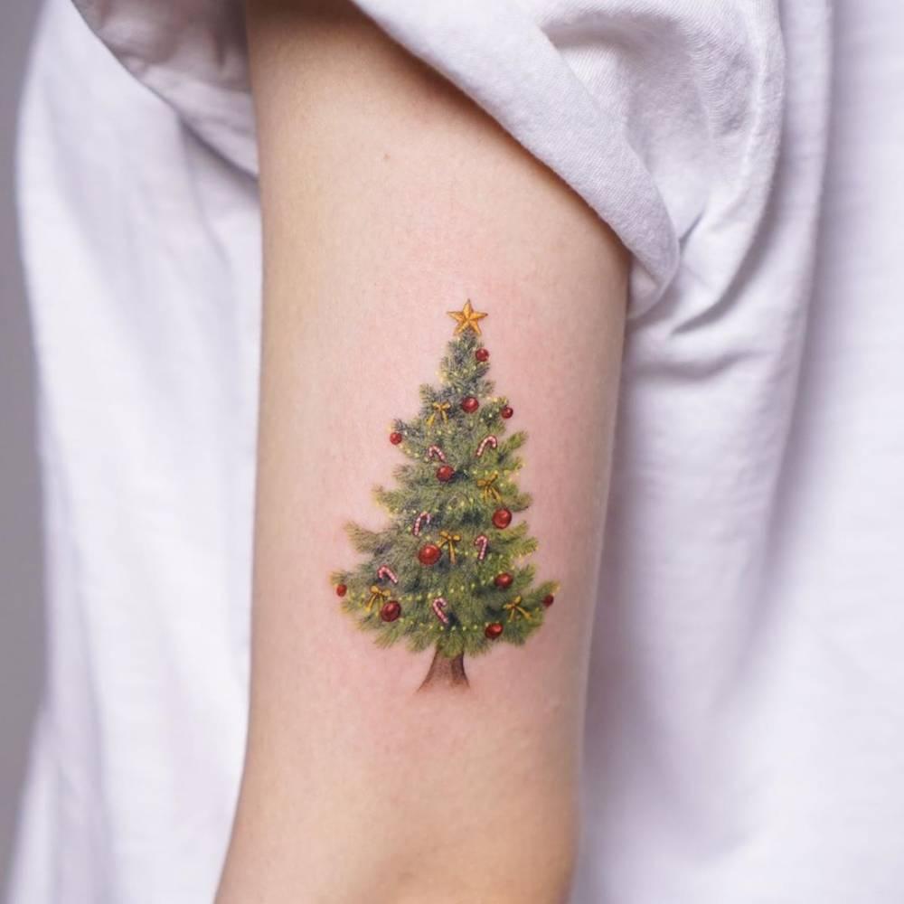 Christmas tree tattoo on the upper arm.