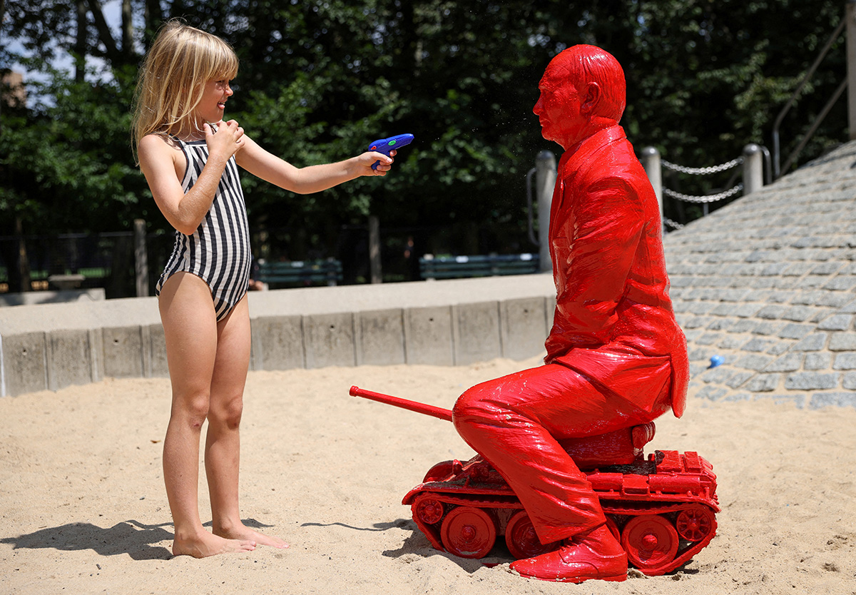 Девочка направляет на скульптуру Владимира Путина игрушечный пистолет, Нью-Йорк, 2 августа 2022 года. Фото: Reuters