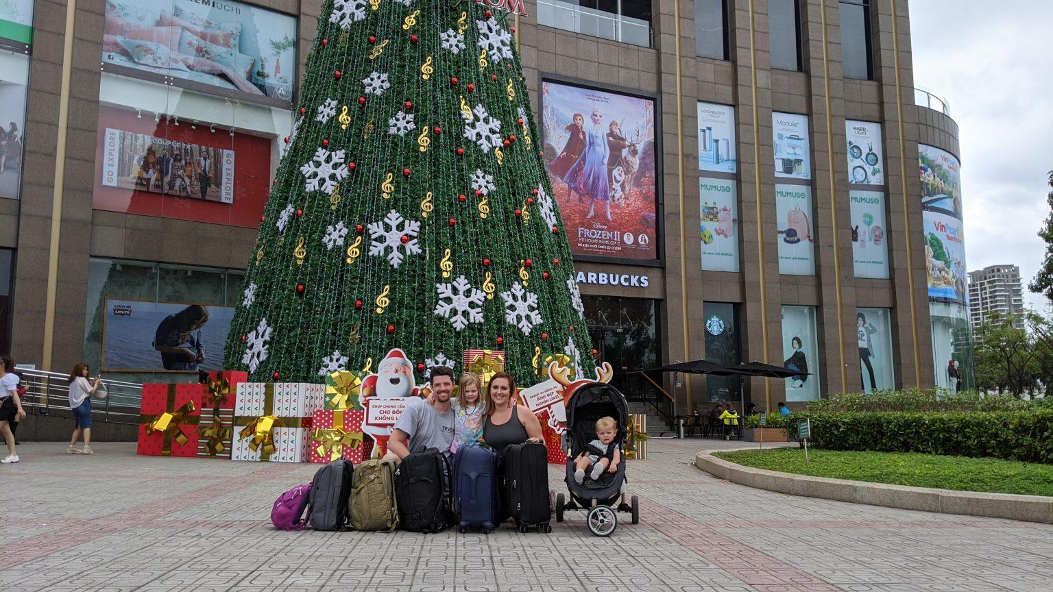 A group of people sitting next to a christmas tree

Description automatically generated with medium confidence