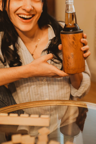 woman holding drink tumbler at table.