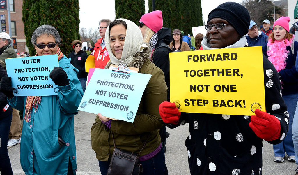 Image of three women holding signs demanding voting rights