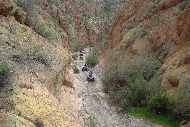 ATV riders riding through a canyon